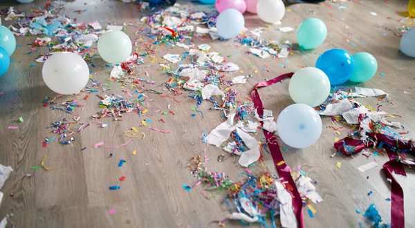 Top view of floor with after a party celebration with empty blue bottles, wine glass and party decorations, messy living room interior, After party chaos, birthday